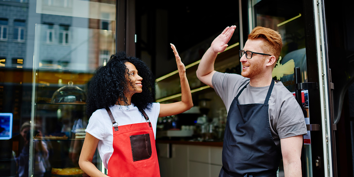 2 entrepreneurs se tapent dans la main devant leur café
